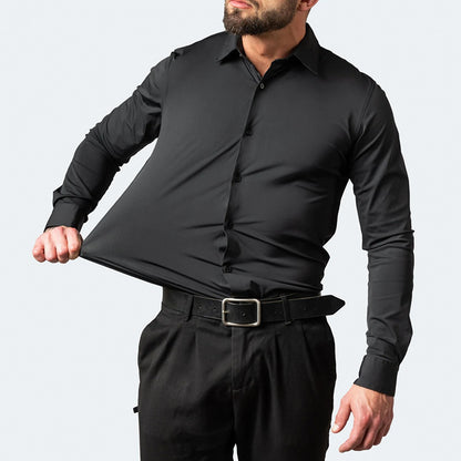 Man wearing a black dress shirt and pants against a gray background